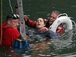 Freezing: Boston firefighters work to rescue a woman who fell into the frigid water of Boston Harbor on Friday