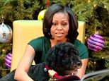 Michelle Obama held the book out in front of Bo so that he could 'read' along with her and the children during the recent Christmas event