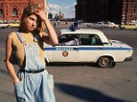 Hard times: Eighteen-year-old Prostitute Katya scours the street for work as a police car drives past in Moscow in 1991 shortly before the collapse of the USSR