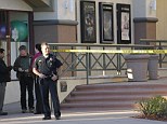 Shooting: Police officers and investigators stand around the scene of a shooting at a San Diego movie theater on Saturday evening that left a suspected gunman critically injured
