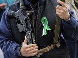 Hartford: A man who refused to be identified holds an AR-15 semi-automatic riffle with a green and white ribbon reading Newtown at the Capitol in Hartford, Connecticut