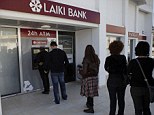 Panic: People queue withdraw their money from an ATM machine outside in Larnaca, Cyprus, after learning that the terms of a bailout deal includes a one-time levy on bank deposits
