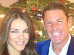 No novelty jumpers here: Liz Hurley and Shane Warne pose by the tree