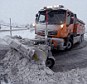 Icy grip: The UK is being hit with even more heavy snow today as a plough tries to clear snow from the A66 dual carriageway after it was closed between County Durham and Cumbria this morning