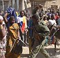 Deployment: A Malian soldier tries to disperse looters in the streets of Timbuktu. The UK today announced it was sending 330 troops to the troubled West African state 