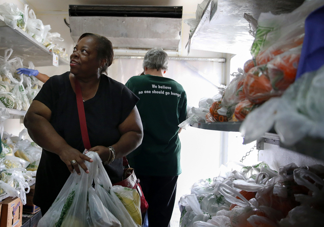 Carmelita Dorsey looks at fresh fruits inside a refrigerator truck at Oak Forest Health Center